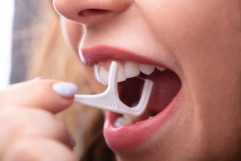 Close-up of woman using floss pick