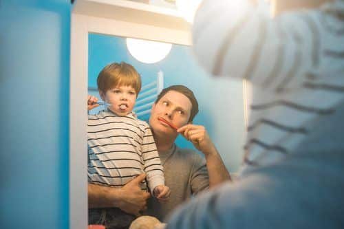 Dad and son brushing teeth