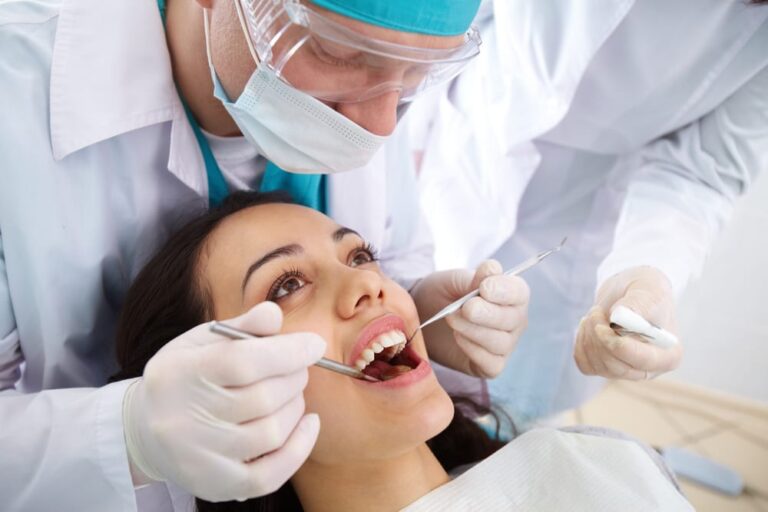 Dentist-looking-in-mouth-of-female-patient