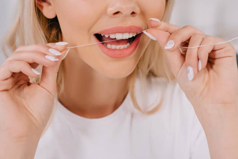 Close-up of woman flossing her teeth