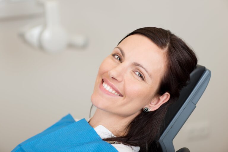 Young woman smiling while sitting in dentist chair