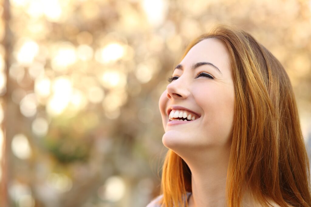 Young woman smiling outside