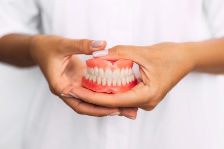 Hands holding dentures