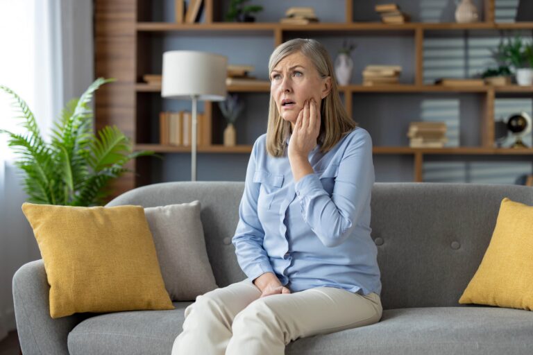 Adult woman holding hand to her mouth, looking concerned
